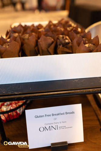 Tray of gluten-free breakfast breads in brown paper cups displayed in a white ribbed box.