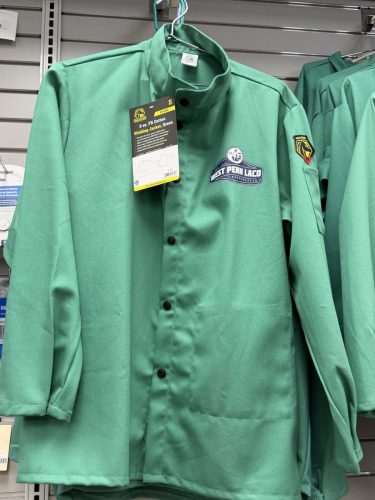 Green welding jacket on a hanger with a Black Stallion tag; chest patch reads 'West Penn Lac'